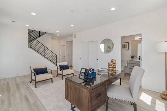 Modern office with desk, chairs, and staircase