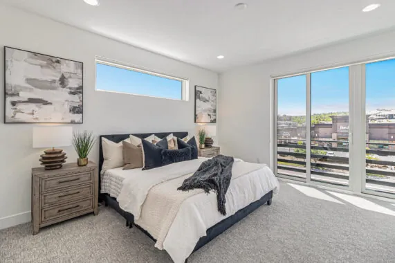 Modern bedroom with large window, sliding doors, and abstract art